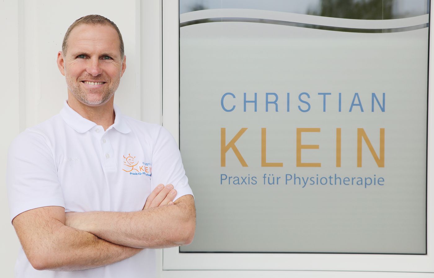 Christian Klein vor dem Praxisschild
